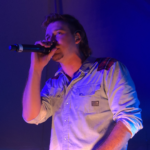 Morgan Wallen singing into a microphone during a concert