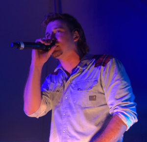 Morgan Wallen singing into a microphone during a concert