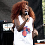 SZA singing in a white basketball jersey at the 2015 AfroPunk Festival