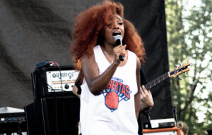 SZA singing in a white basketball jersey at the 2015 AfroPunk Festival
